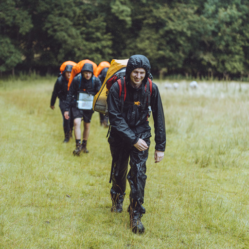 men connecting with nature in rain with backpacks