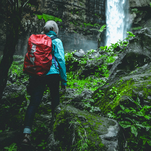 woman hiking and connecting with nature by waterfalls