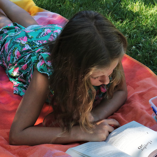 tween girl reading outdoor adventure book